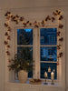 Lichterkette mit roten Beeren und Zapfen
